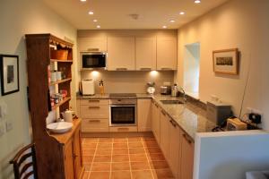 a kitchen with white cabinets and a counter top at Finest Retreats - Ingleby Manor - Manor Cottage in Great Ayton