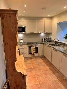 a kitchen with white cabinets and a counter top at Finest Retreats - Ingleby Manor - Manor Cottage in Great Ayton