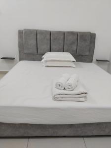 a bed with towels and pillows on it at Happy Chamang Guest House in Bentong