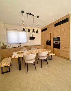 een keuken met een grote houten tafel en stoelen bij Emerald villa Yenibogazici in Yenibosazici