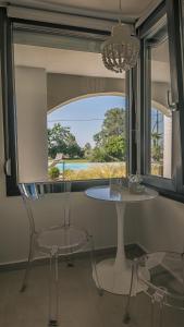 a table and chairs in a room with a window at Electra BeachFront Suites, Nea Irakleia in Nea Iraklia