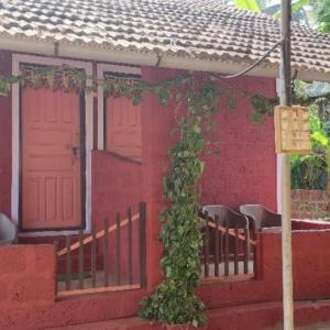 a red house with a red door and a vine at Samarth Atc-Beach Home Stay in Ratnagiri