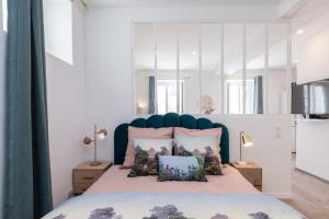 um quarto com uma cama com uma cabeceira e almofadas azuis em Lovely Apartment City Center Heart - AC em Nice