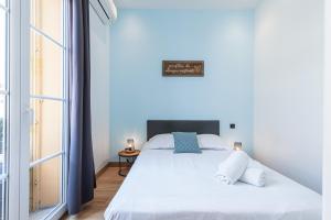 a bedroom with a large white bed and a window at Garibaldi Square - Cosy 1bdr in the Old Town in Nice
