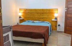 a bedroom with a large bed with a wooden headboard at Villa Tilapia Tropical in Capesterre-Belle-Eau