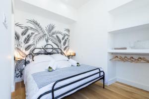 een slaapkamer met een bed met tropisch behang bij Cosy 1 Bdr Place Garibaldi & Place du Pin in Nice