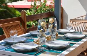 a table set with plates and glasses and christmas decorations at Villa Tilapia Tropical in Capesterre-Belle-Eau