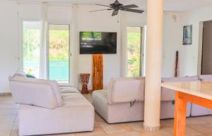 a living room with two couches and a tv at Villa Tilapia Tropical in Capesterre-Belle-Eau