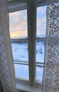 una ventana con vistas a un campo cubierto de nieve en Norrsjön, en Sörsjön