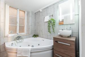 ein weißes Badezimmer mit einer Badewanne und einem Waschbecken in der Unterkunft Cosy Studio in the Old Town near Garibaldi Square in Nizza