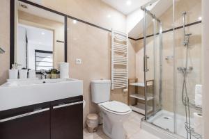 La salle de bains est pourvue de toilettes et d'une douche en verre. dans l'établissement Massena Street - 1 Bdr Duplex with AC & Parking, à Nice
