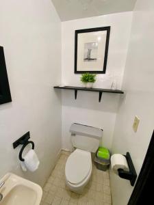 uma casa de banho com um WC branco e um lavatório. em Jaguar Studio em Tijuana