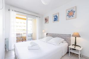 a white bedroom with a bed and a table at Quiet 1 bdr Port! close Place du Pin Garibaldi in Nice