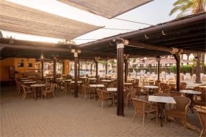 an outdoor patio with tables and chairs and tables and tablesktop at Vila Gale Isla Canela in Isla Canela