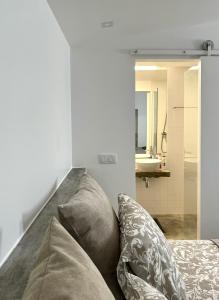 a room with a couch with pillows and a mirror at Casa Pátio Boa Vista 4 in Setúbal