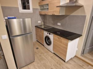 a kitchen with a stainless steel refrigerator and a washing machine at Flat City Center Mindelo in Mindelo