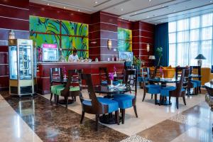 um restaurante com mesas e cadeiras e um bar em Plaza Inn Doha em Doha