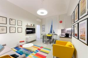 ein Wohnzimmer mit einem gelben Stuhl und einem Tisch in der Unterkunft JOIVY The Place To Be in the Centre of Genoa in Genua
