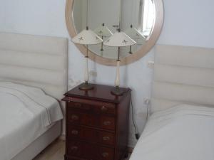 a bedroom with a mirror and a dresser with a bed at In front of the Beach. in Khónai