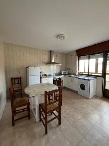 a kitchen with a table and chairs and a kitchen with a stove at Casa Vazan in Laguna Dalga