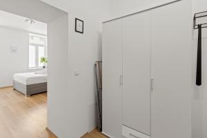 Habitación blanca con cama y puerta corredera de cristal en StayEasy Apartments Vienna A#2, en Viena