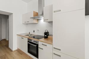 una cocina con armarios blancos y fregadero en StayEasy Apartments Vienna A#2, en Viena