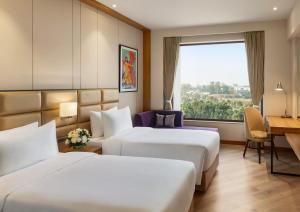 Postel nebo postele na pokoji v ubytování Ramada Encore by Wyndham Amritsar Airport