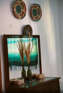 a table with two vases and plates on a wall at Onda Surf in Taghazout