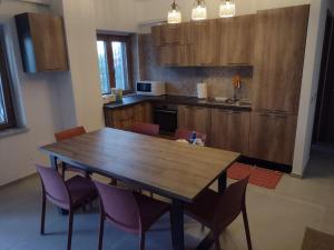 cocina con mesa de madera y sillas moradas en Soverato con Vista, en Soverato Marina