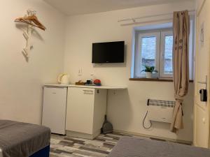 a bedroom with a desk and a television on the wall at House Gorica in Šibenik