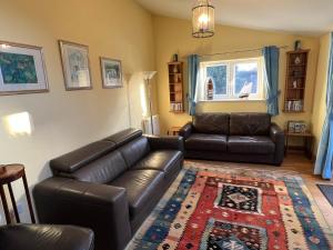 a living room with a leather couch and a table at Honeycomb House Apartments in Hunstanton