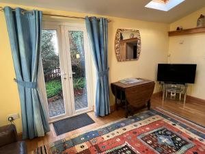 a living room with blue curtains and a television at Honeycomb House Apartments in Hunstanton