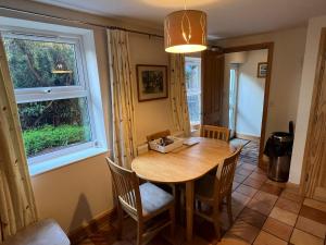 comedor con mesa, sillas y ventana en Honeycomb House Apartments, en Hunstanton