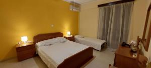 1 Schlafzimmer mit 2 Betten und einem Fenster mit 2 Lampen in der Unterkunft Alianthos Beach Apartment in Vari