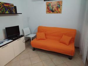 an orange couch and a chair in a room at Al Vicoletto in Trapani