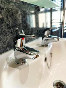 a bathroom sink with a chrome faucet on it at The Quies in Newquay +37 photos