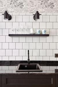 uma cozinha com um lavatório e uma parede de azulejos brancos em "Breeze" Aparthotel by Parrot`s House em Lloret de Mar