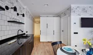 a kitchen with white cabinets and a table and a sink at "Breeze" Aparthotel by Parrot`s House in Lloret de Mar