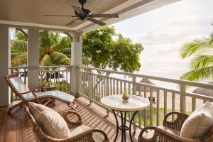 eine Veranda mit Stühlen, einem Tisch und Meerblick in der Unterkunft JW Marriott Mauritius Resort in Le Morne