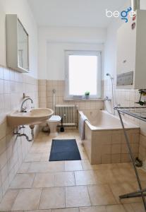 ein Badezimmer mit einer Badewanne, einem Waschbecken und einem WC in der Unterkunft BEGE APARTMENTS: WORK HEAVEN in Gelsenkirchen