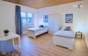 1 Schlafzimmer mit 2 Betten und einem Schreibtisch in der Unterkunft BEGE APARTMENTS: WORK HEAVEN in Gelsenkirchen