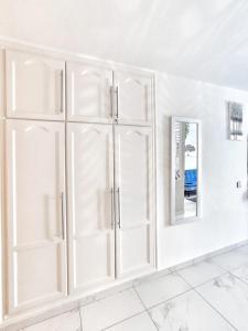 a white room with white cabinets and a mirror at Sunshine Escape with ocean view in Adeje