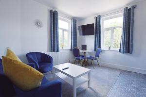 a living room with a couch and chairs and a table at Allerdale in Torquay