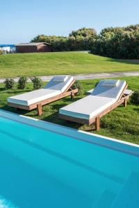 two beds sitting next to a swimming pool at Bella Beach Hotel in Hersonissos