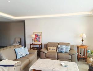 Sala de estar con 2 sofás y mesa en Soleil Soleil, Villa sur le toit grande terrasse, en Saint-Raphaël