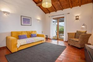 ein Wohnzimmer mit einem gelben Sofa und einem Stuhl in der Unterkunft Burro Ville by Host Wise in Portimão