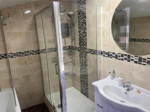 a bathroom with a shower and a sink and a mirror at Rahal Compton in London