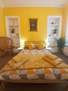 um quarto com uma cama grande e paredes amarelas em Beautiful Two Bedroom ground floor apartment em Swansea
