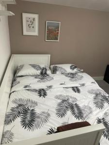 - un lit avec une couette et des oreillers en noir et blanc dans l'établissement Rahal Compton, à Londres