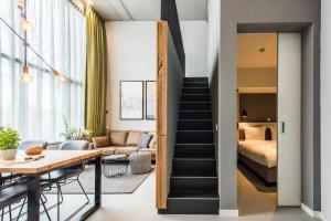 a living room and bedroom with a bed and a table at YAYS Amsterdam East by Numa in Amsterdam